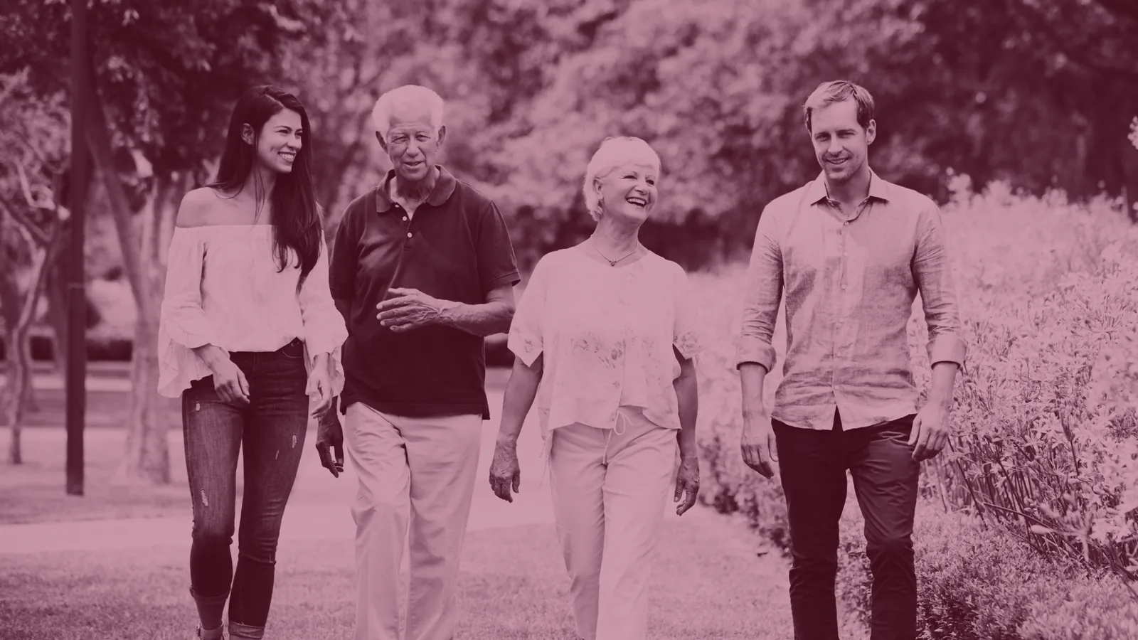 Red-tinted photo of an older couple walking outdoors with their two adult children.